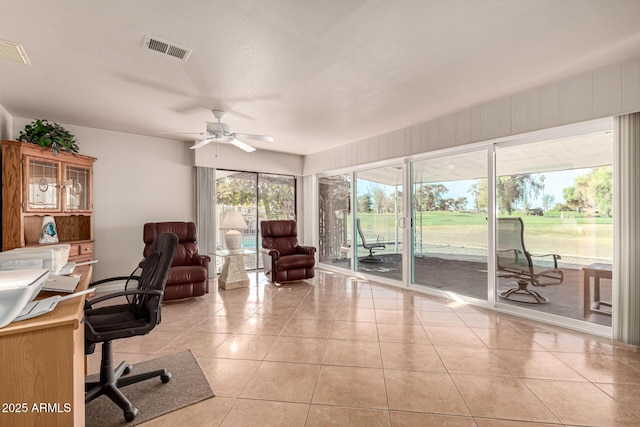 home office with light tile patterned floors and ceiling fan