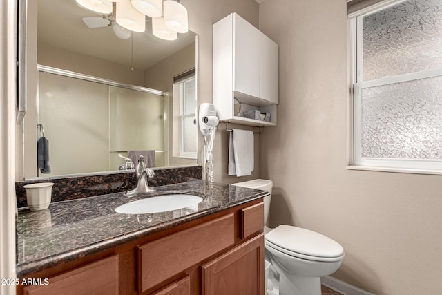 bathroom featuring vanity, toilet, and an enclosed shower