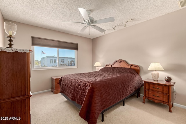 bedroom with light colored carpet, a textured ceiling, and ceiling fan