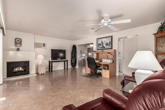 living room featuring a wall mounted air conditioner, ceiling fan, tile patterned floors, and a fireplace