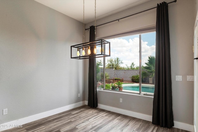 2761 W Via Calabria, Phoenix, AZ 85086 - unfurnished dining area with a chandelier, baseboards, and wood finished floors