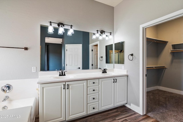 2761 W Via Calabria, Phoenix, AZ 85086 - full bathroom featuring double vanity, a bath, wood finished floors, a walk in closet, and baseboards