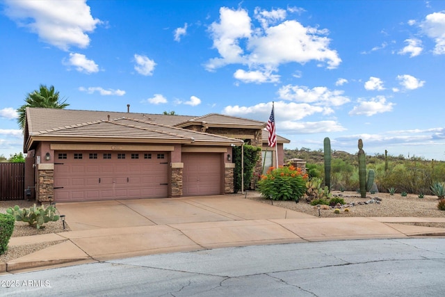 2761 W Via Calabria, Phoenix, AZ 85086 - view of front of property with stone siding, concrete driveway, an attached garage, stucco siding, and a tiled roof