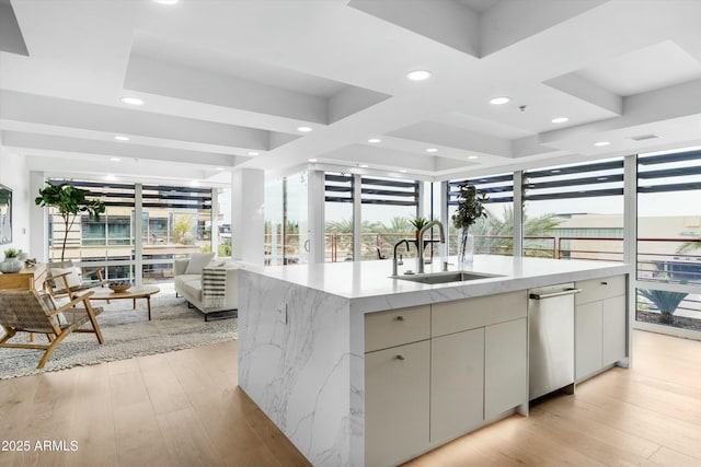 kitchen featuring open floor plan, a sink, light wood-style flooring, and modern cabinets