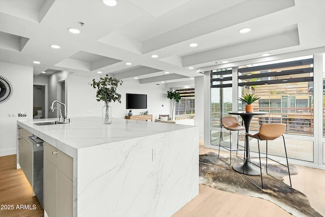 kitchen featuring recessed lighting, a sink, a center island with sink, and light wood-style floors