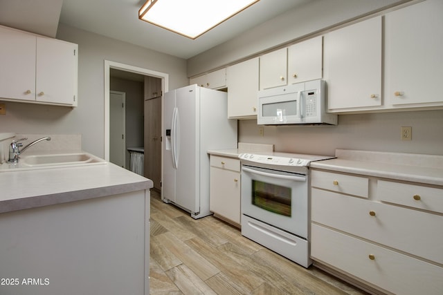 kitchen featuring white cabinetry, sink, white appliances, and light wood-type flooring