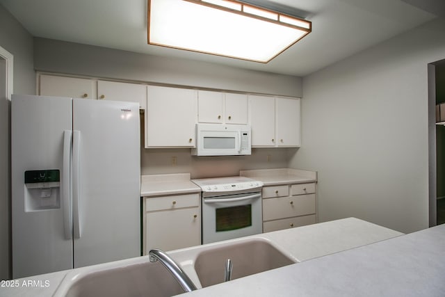 kitchen with sink, white appliances, and white cabinets