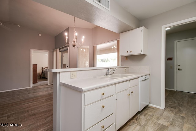 kitchen with decorative light fixtures, dishwasher, white cabinetry, lofted ceiling, and sink