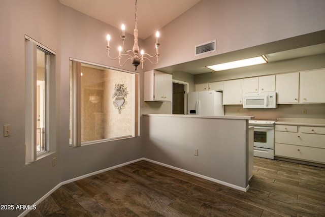 kitchen with white appliances, dark wood-type flooring, white cabinetry, hanging light fixtures, and kitchen peninsula