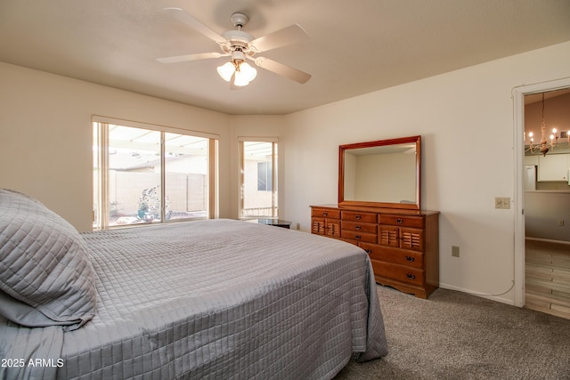 carpeted bedroom with ceiling fan with notable chandelier