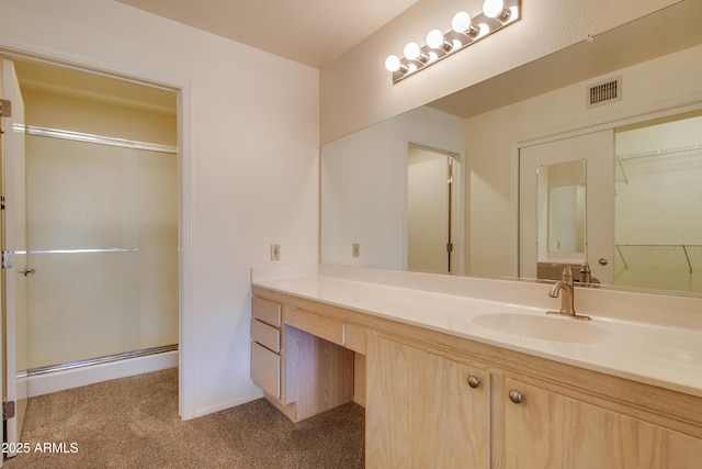 bathroom with vanity and a shower with door