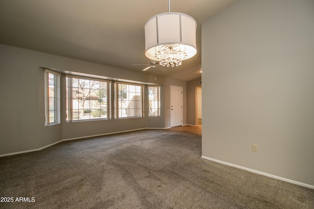 carpeted spare room featuring a notable chandelier