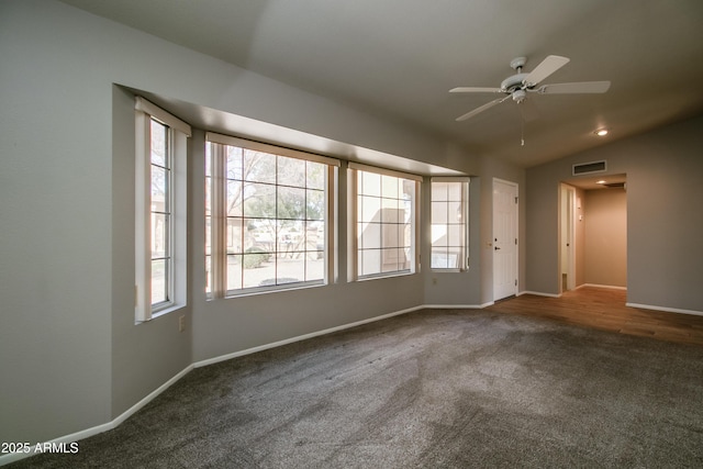 carpeted spare room featuring vaulted ceiling and ceiling fan