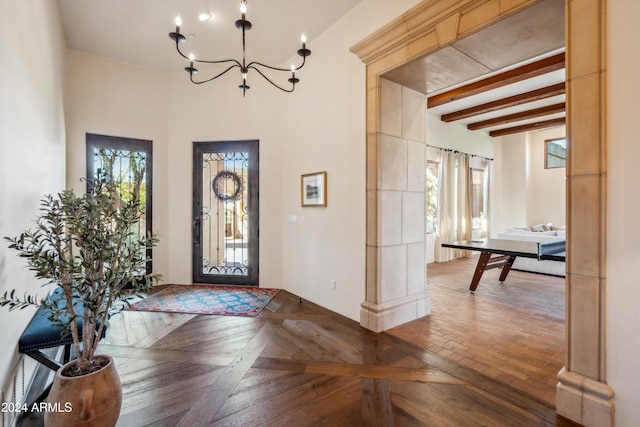 foyer entrance featuring parquet flooring, beam ceiling, and a chandelier