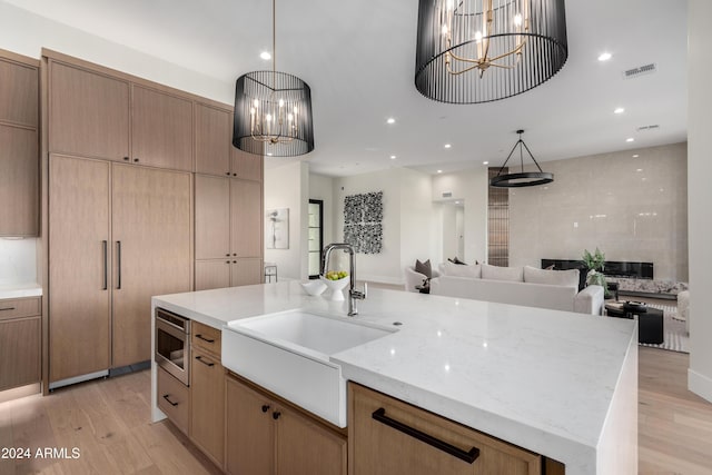 kitchen featuring an inviting chandelier, hanging light fixtures, a spacious island, and sink