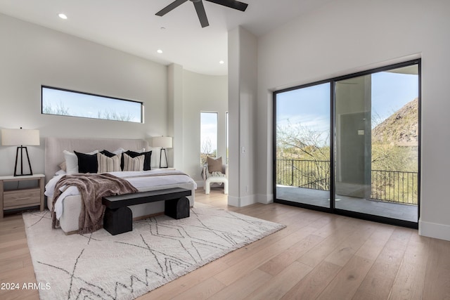 bedroom featuring access to exterior, a high ceiling, light hardwood / wood-style floors, and ceiling fan