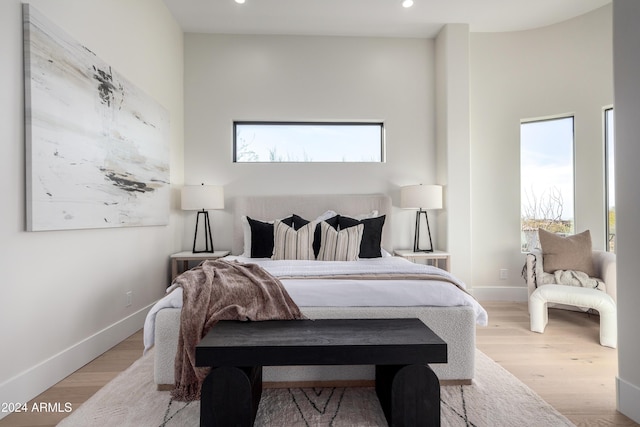 bedroom with light wood-type flooring and multiple windows