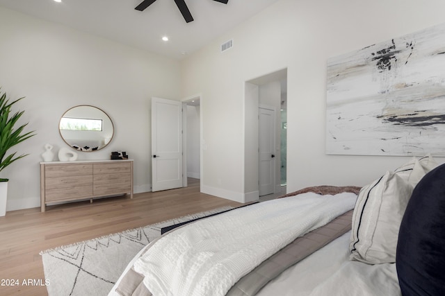 bedroom with light wood-type flooring, high vaulted ceiling, and ceiling fan