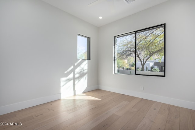 empty room with light hardwood / wood-style floors, ceiling fan, and a healthy amount of sunlight