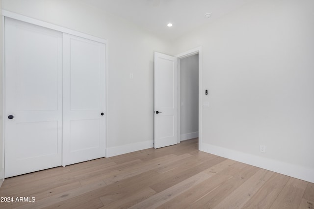 unfurnished bedroom featuring light hardwood / wood-style floors and a closet