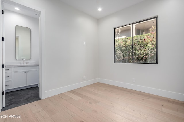 unfurnished room with light hardwood / wood-style flooring and sink