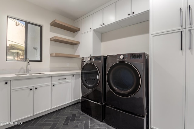 laundry area featuring separate washer and dryer, sink, and cabinets