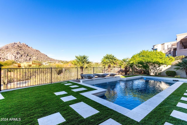 view of swimming pool featuring a mountain view and a yard