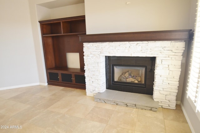 interior details featuring a stone fireplace and baseboards