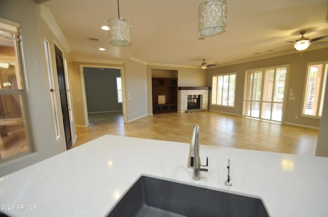 kitchen with ornamental molding, open floor plan, light countertops, and a sink