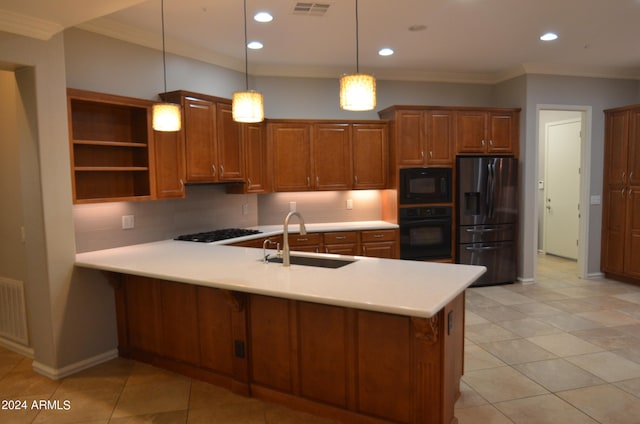 kitchen featuring hanging light fixtures, light countertops, black appliances, open shelves, and a sink