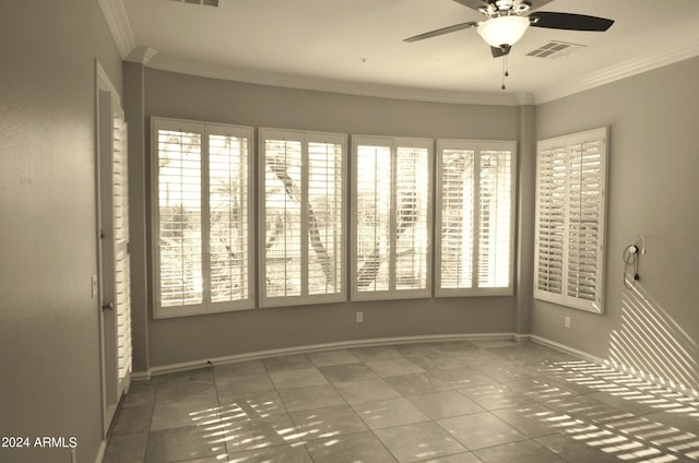 spare room with baseboards, a ceiling fan, visible vents, and crown molding