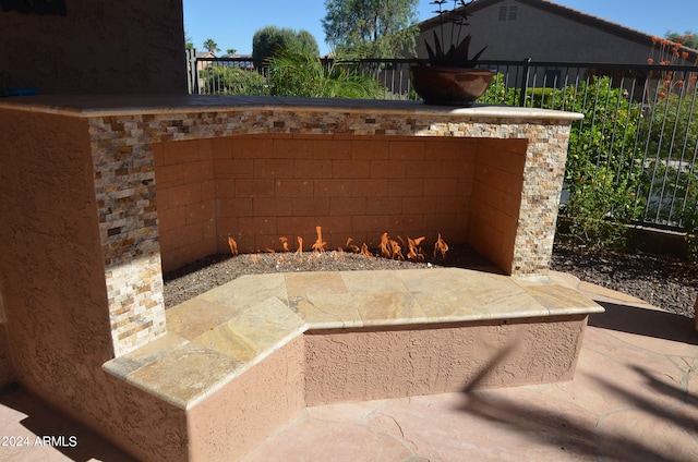 view of patio / terrace featuring exterior fireplace and fence