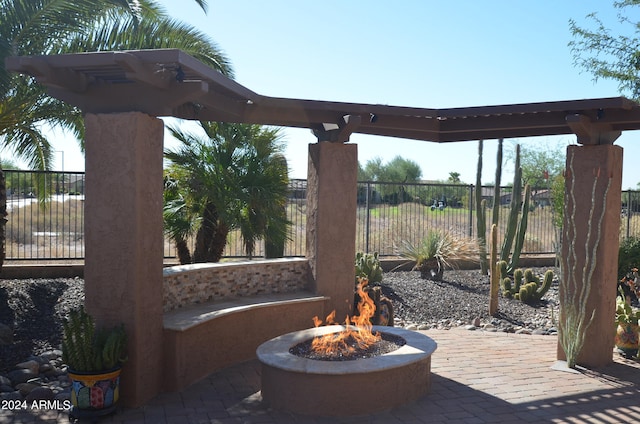 view of patio / terrace featuring an outdoor fire pit and fence