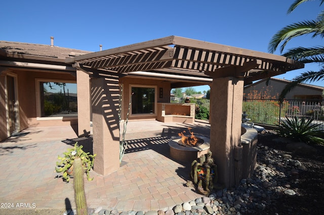 view of patio featuring a fire pit, fence, and a pergola