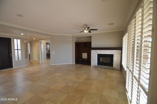 unfurnished living room featuring visible vents, ornamental molding, ceiling fan, a stone fireplace, and baseboards