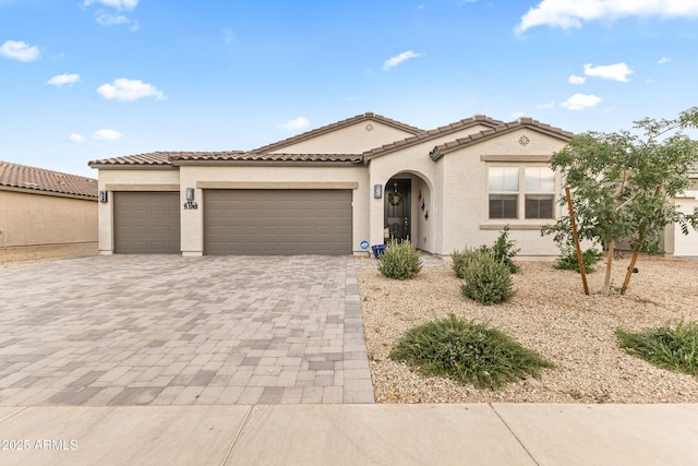 1749 W Posada St, Coolidge, AZ 85128 - mediterranean / spanish home featuring an attached garage, decorative driveway, stucco siding, and a tile roof