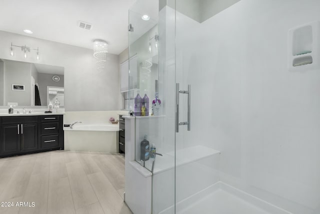 bathroom with shower with separate bathtub, vanity, and hardwood / wood-style floors