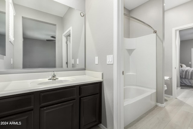 full bathroom featuring toilet,  shower combination, vanity, and hardwood / wood-style flooring