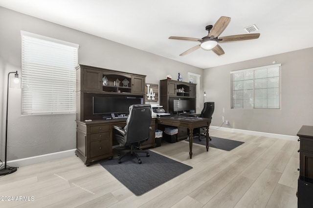 office space featuring ceiling fan, light hardwood / wood-style flooring, and a healthy amount of sunlight