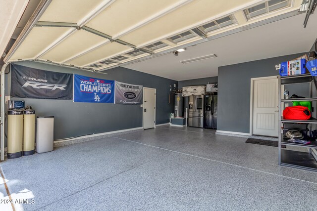 garage featuring electric water heater and stainless steel fridge