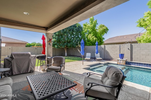 view of patio featuring pool water feature, a fenced in pool, and a grill