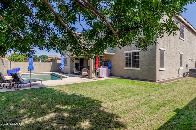 rear view of house with a fenced in pool, a patio area, and a yard