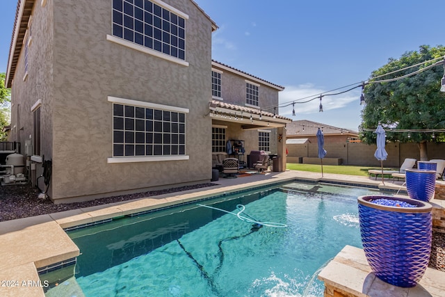 view of swimming pool with pool water feature and grilling area