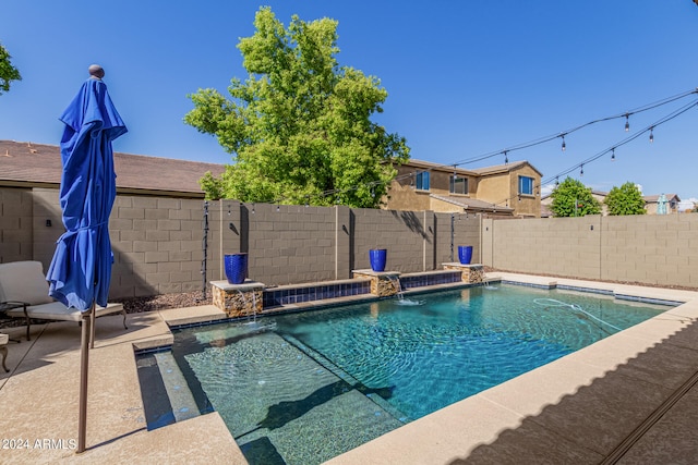 view of swimming pool featuring pool water feature and a patio area