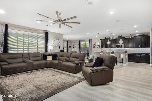 living room with ceiling fan and light wood-type flooring