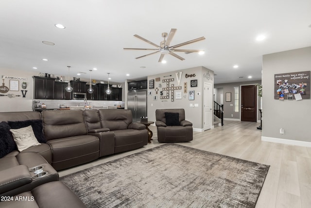 living room featuring ceiling fan and light hardwood / wood-style flooring