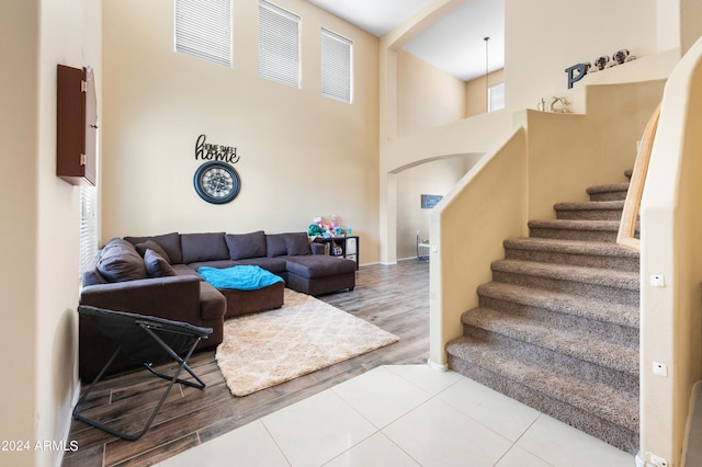 living room with a towering ceiling and hardwood / wood-style flooring