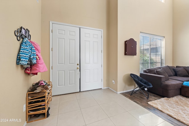 entryway featuring a high ceiling and light tile patterned floors