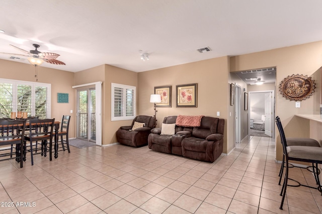 living room with light tile patterned floors, baseboards, visible vents, and ceiling fan