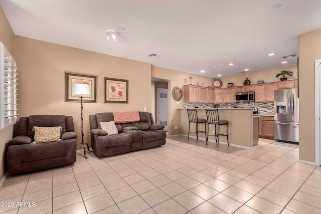 living area featuring light tile patterned flooring, recessed lighting, visible vents, and baseboards